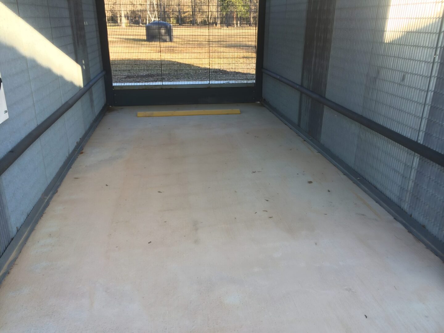 Empty cage with fenced walls and floor.